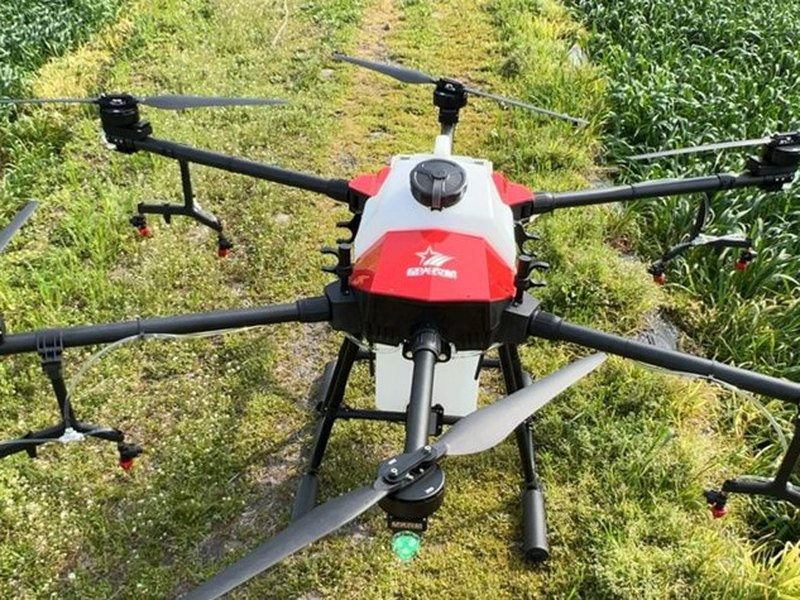 Agricultural spraying drone over a cultivated field