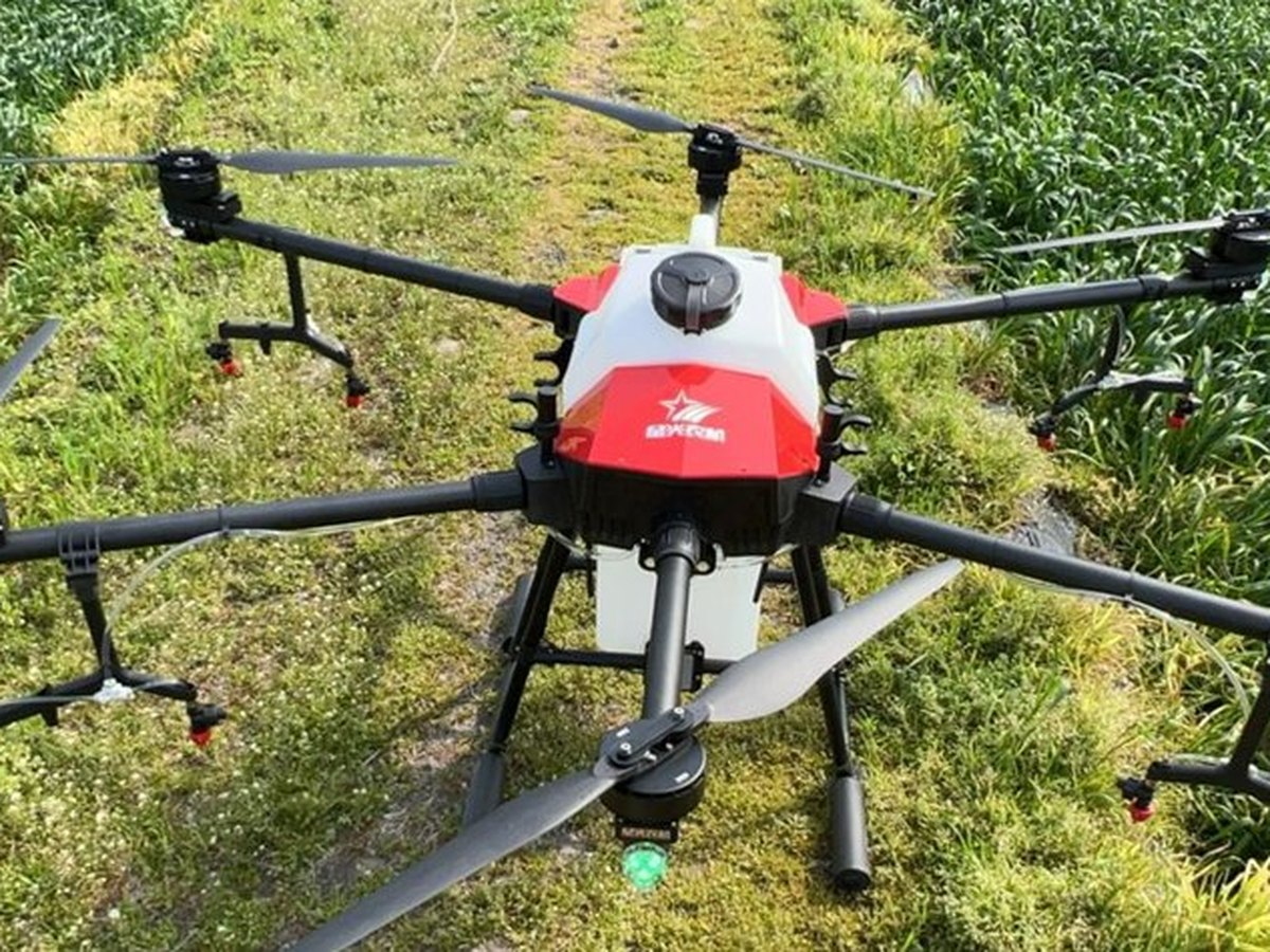 Agricultural spraying drone over a cultivated field